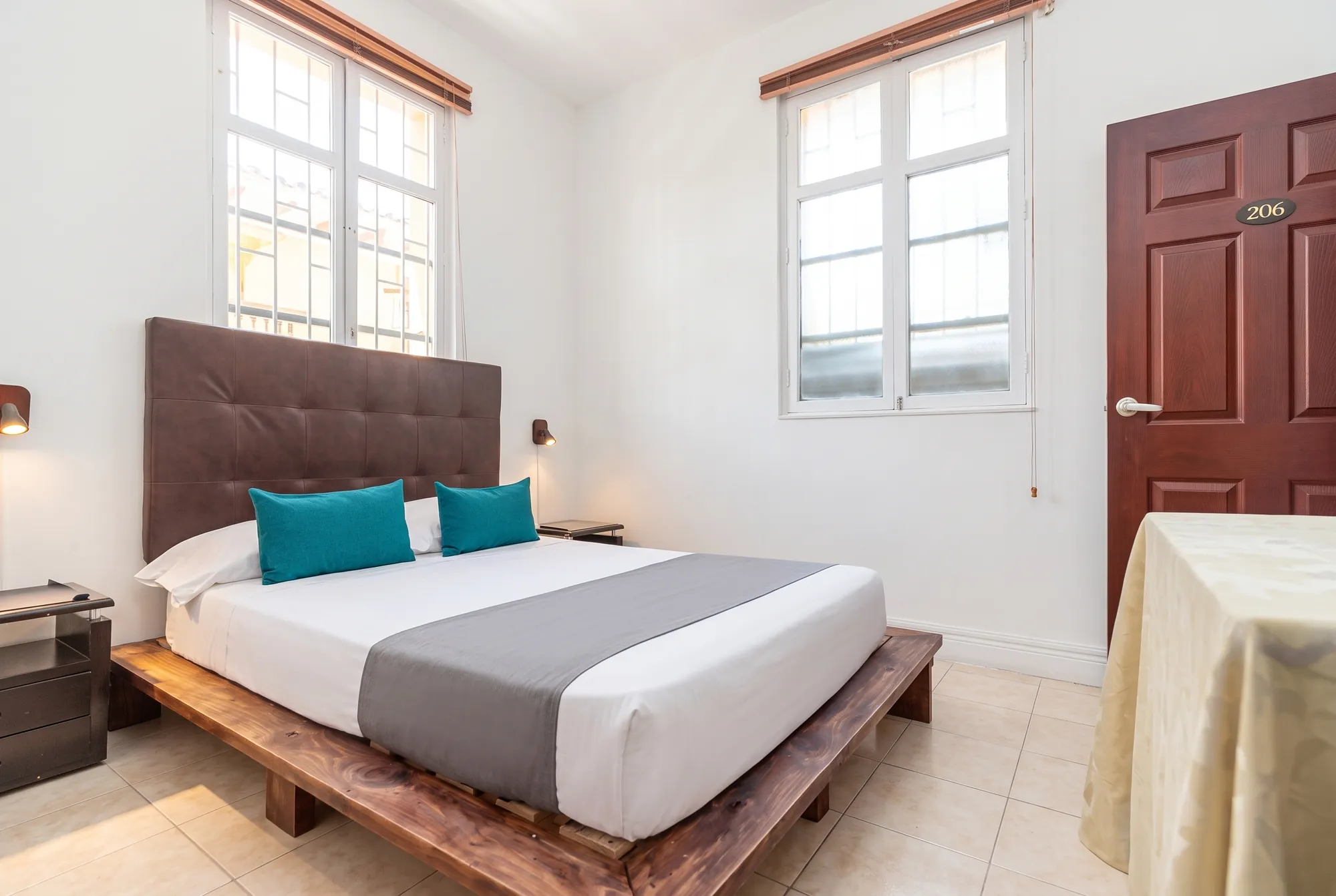 Habitación con cama doble, cabecero capitoneado y ventanales