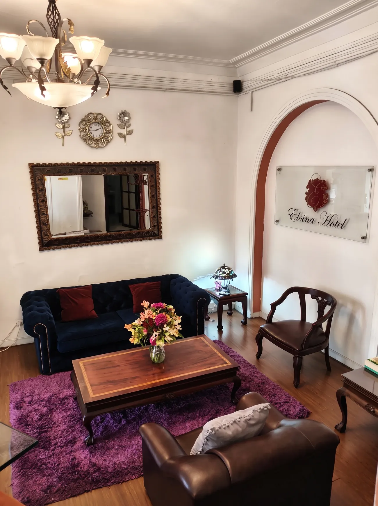 Sala de recibo con arcos, lámpara de araña y sofá de terciopelo