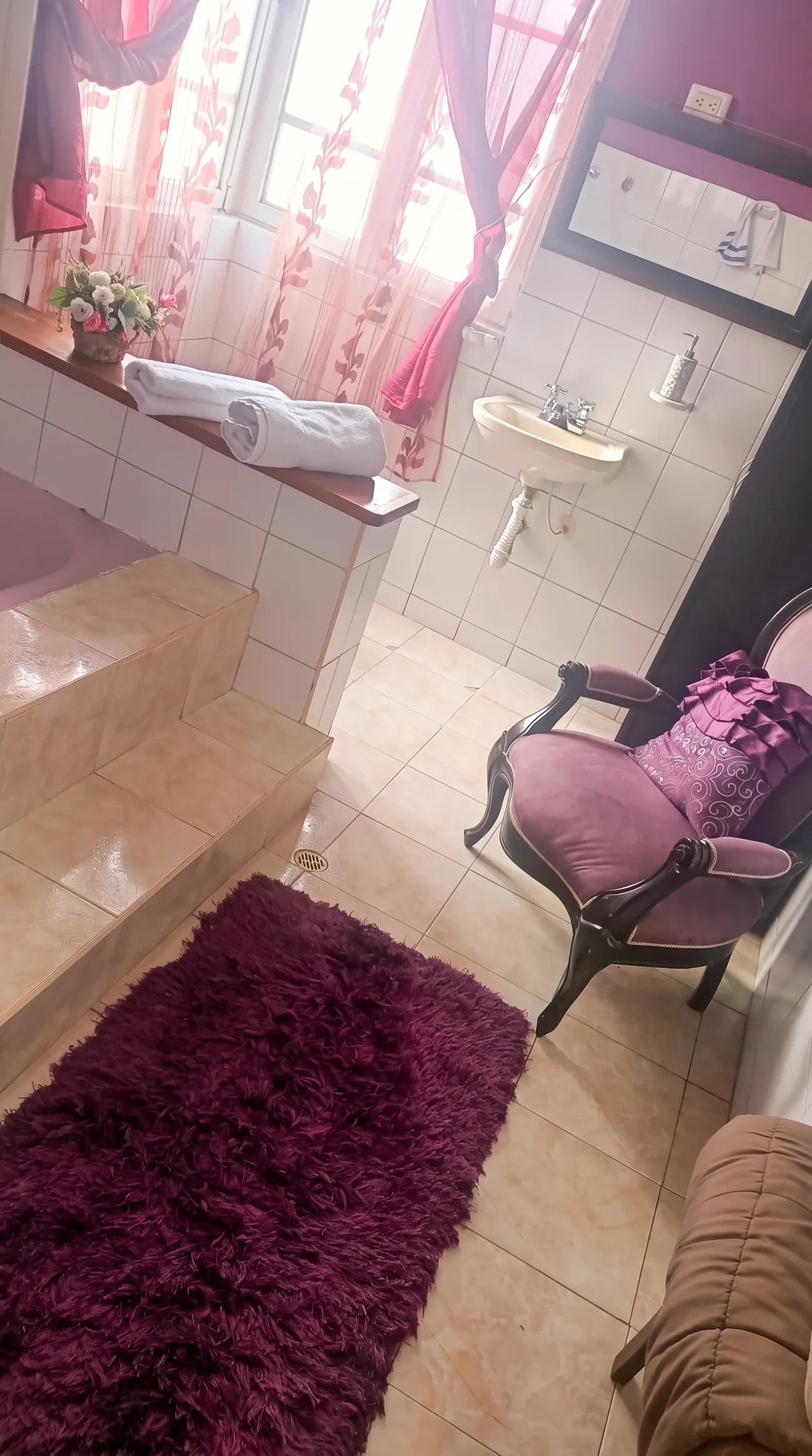 Suite con tina, sillón de terciopelo y tapete