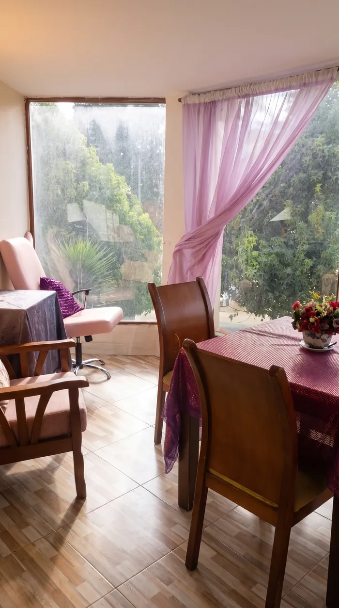Ventanal con cortina y mesa con flores